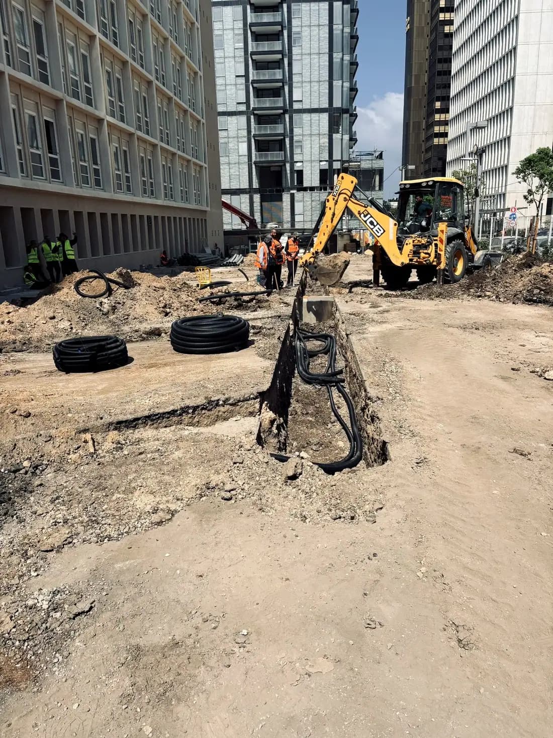 צוות הביצוע מניח כבלים וצנרת בחניון בית הוועד הפועל